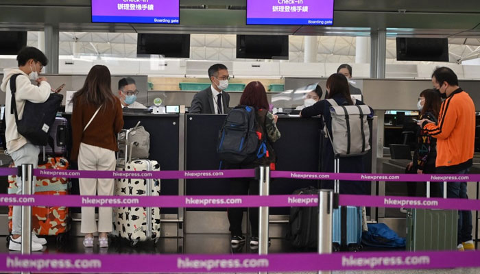 Passengers check-in at the HK Express counter at the international airport in Hong Kong on December 28, 2022. — AFP/File