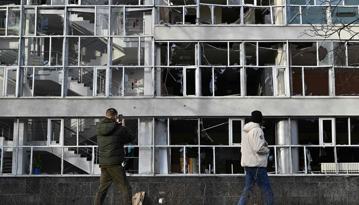 Görgü tanıkları, Kiev'de bir füze tarafından hasar gören bir eğitim binasına bakıyor.  — AFP