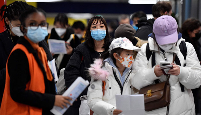 Passengers of a flight from China wait in a line for checking their COVID-19 vaccination documents as a preventive measure against the Covid-19 coronavirus, after arriving at the Paris-Charles-de-Gaulle airport in Roissy, outside Paris, on January 1, 2023. — AFP