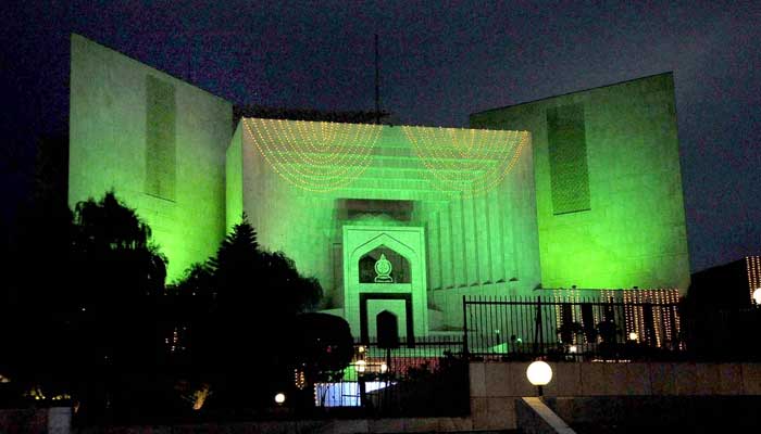 13 Ağustos 2022'de İslamabad'da Bağımsızlık Günü kutlamalarının arifesinde renkli ışıklarla süslenmiş Yargıtay binasının göz alıcı bir görüntüsü. — APP