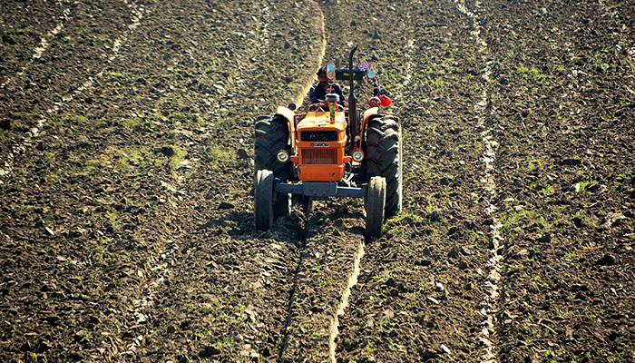 A farmer levels his farm field with the help of a tractor in Hyderabad on October 19, 2022. — APP