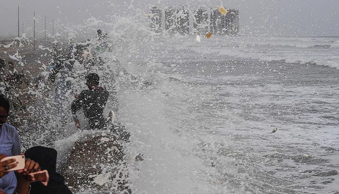 People gather at Seaview beach during a high tide in Karachi in this undated file photo. — AFP/File