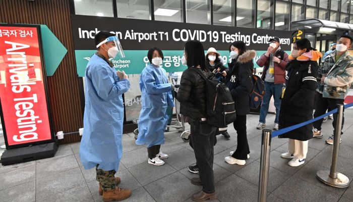 Health workers guide travelers arriving from China in front of a COVID-19 testing center at Incheon International Airport, Seoul, South Korea, Jan 03, 2023.— AFP