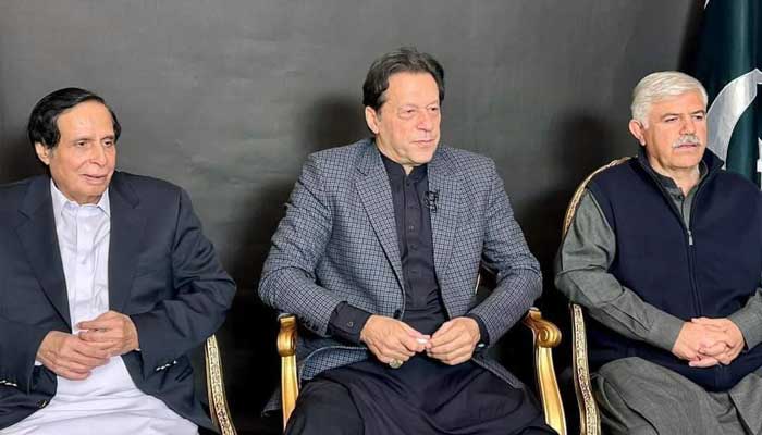 PTI Chairman Imran Khan (centre) sits with Punjab CM Chaudhry Parvez Elahi (left) and KP CM Mahmood Khan ahead of his video link address on December 18, 2022. — Twitter/@KPChiefMinister