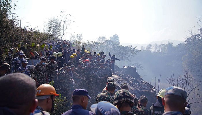 Rescuers gather at the site of a plane crash in Pokhara on January 15, 2023. — AFP