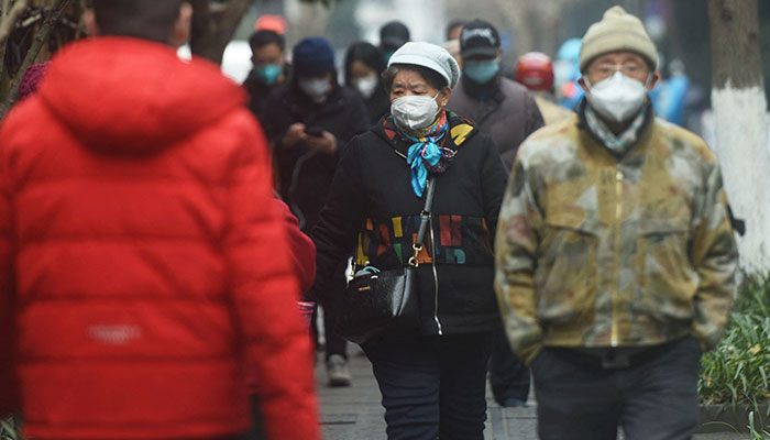 Residents walk along a street in Hangzhou, in China´s eastern Zhejiang province on January 17, 2023.