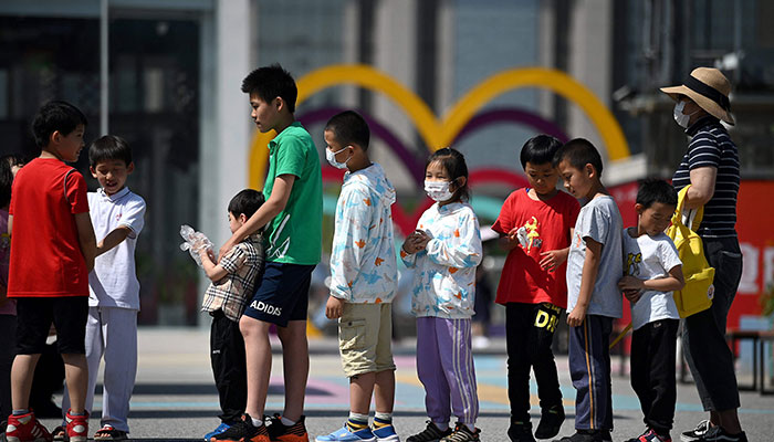 In this file photo taken on June 1, 2021 children queue for their turn on a slide on International Children´s Day in Beijing. — AFP
