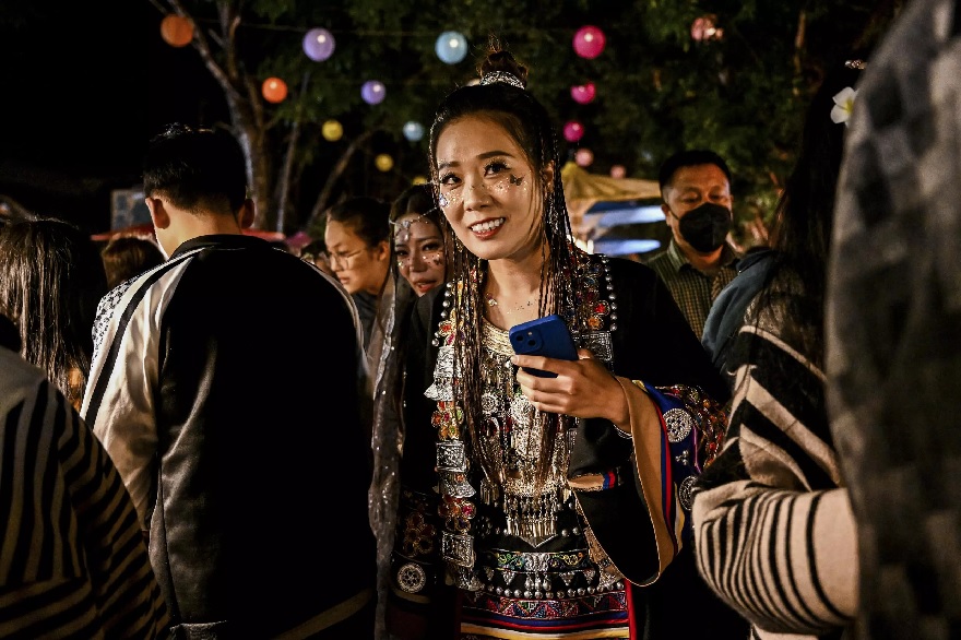Xishuangbanna'daki Jinghong şehrinde bir gece pazarında bir kadın geleneksel kıyafetler giyiyor.— AFP/dosya