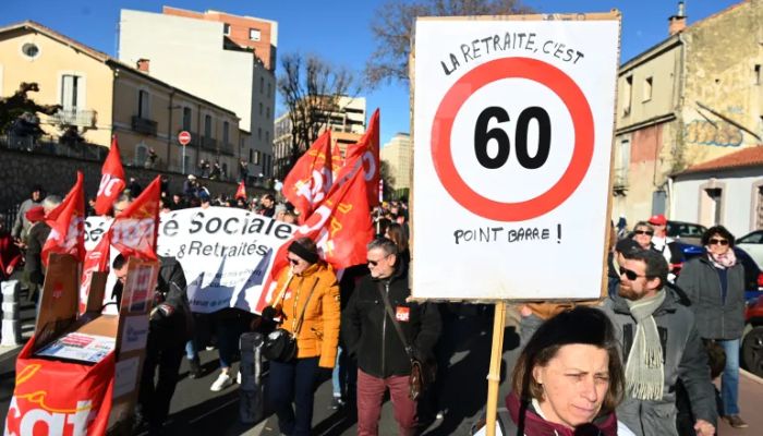 Güney Fransa'nın Montpellier kentinde Fransız sendikaları tarafından düzenlenen bir miting sırasında bir kadın, üzerinde Emeklilik 60 yaşında yazan bir pankart tutuyor.— AFP/file