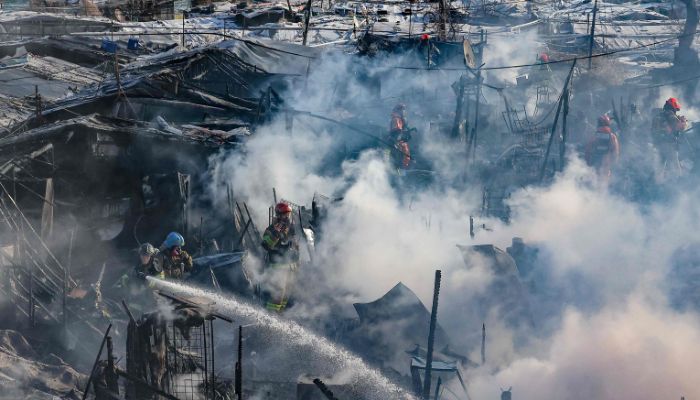 İtfaiyeciler, 20 Ocak 2023'te Güney Seul'de Güney Kore'nin kalan son gecekondu mahallelerinden biri olan Guryong köyünde çıkan yangını söndürmeye çalışıyor.— AFP