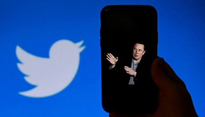 A phone screen displays a photo of Elon Musk with the Twitter logo shown in the background, in Washington, DC, October 4, 2022.— AFP