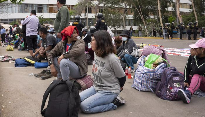 Protestocu olduğu iddia edilen kişiler, 21 Ocak 2023'te Lima'daki San Marcos Üniversitesi kampüsünde tutuklandıktan sonra nakledilmeyi bekliyor.— AFP