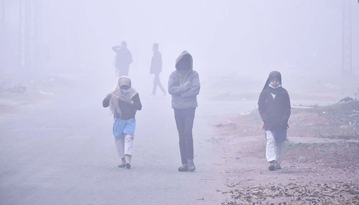 Students are on their way to their school amid dense fog. — APP/File