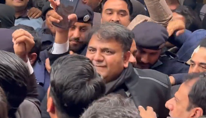 Screengrab of Twitter video showing the police escorting Fawad Chaudhry outside of the district and sessions court on Saturday. — Twitter/File