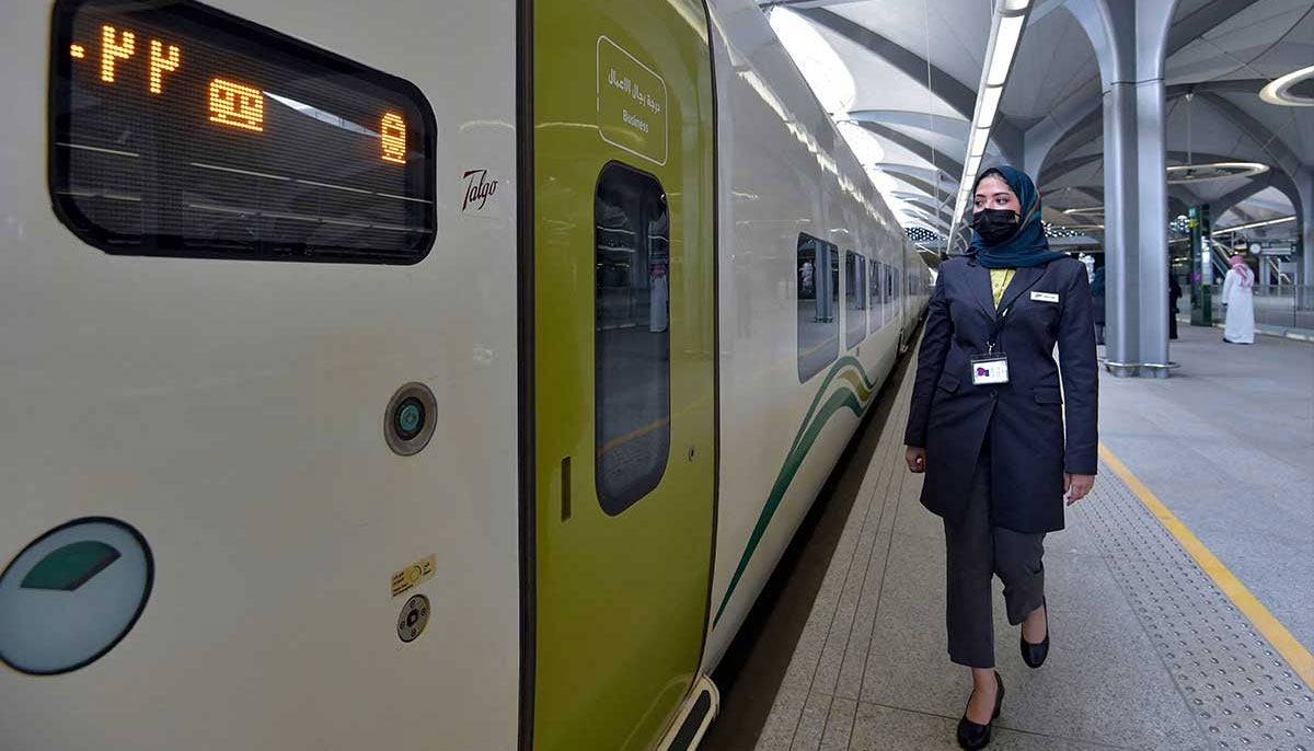 A Saudi conductor walks beside the high-speed train. — AFP