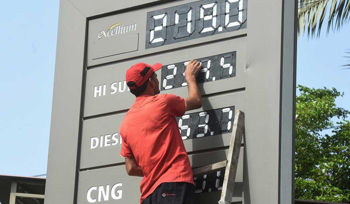 A petrol pump staffer updates rate board with latest fuel prices in Karachi on June 16, 2022. — AFP