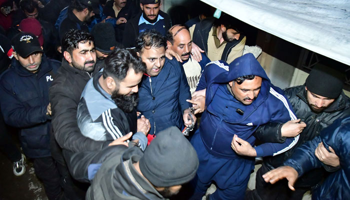 Police officials escort the former information minister Fawad Chaudhry to leave after hearing in a district and session court in Islamabad on January 25, 2023. — Online