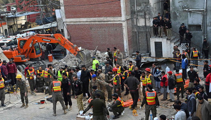 Security personnel and rescue workers prepare to search for the blast victims in the debris of a damaged mosque inside the police headquarters in Peshawar on January 30, 2023. — AFP