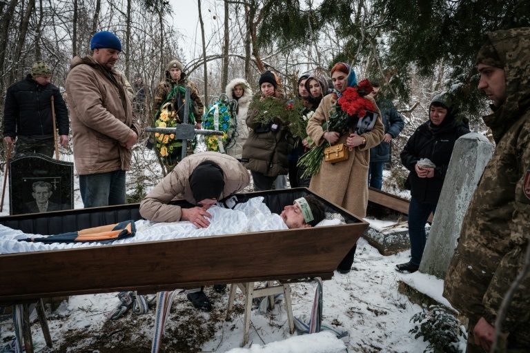 Natalia Shalashnaya (C), 52, mourns over the casket of a Ukrainian serviceman of the Azov battalion killed in action in Bakhmut, 28-year-old Oleksandr Korovn.— AFP