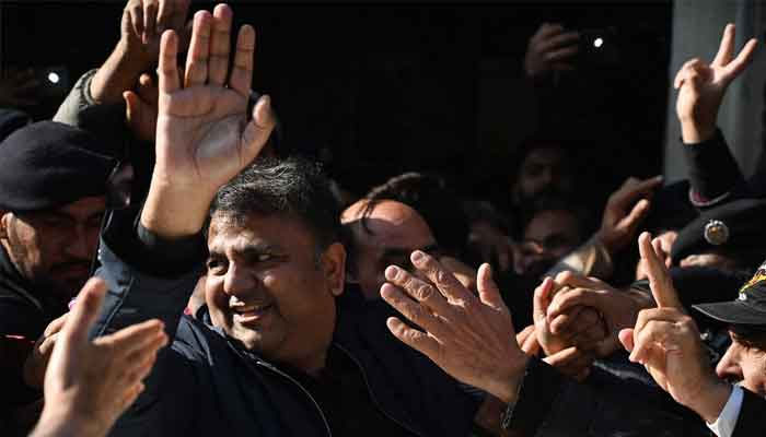 Former information minister Fawad Chaudhry (C) gestures as police officials escort him after a hearing at a court in Islamabad on January 27, 2023. — AFP