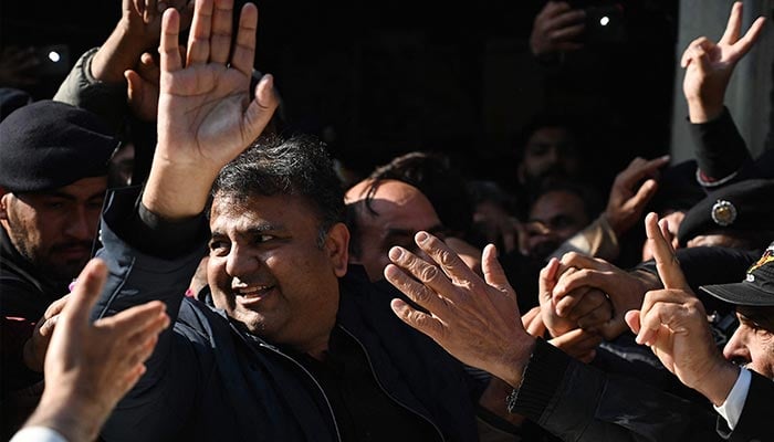Pakistan´s former information minister Fawad Chaudhry (C) gestures as police officials escort him after a hearing at a court in Islamabad on January 27, 2023. — AFP