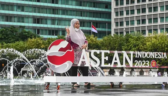 A woman poses with the newly set up logo of the Association of Southeast Asian Nations (ASEAN), as Indonesia officially assumes the groups chairmanship following a ceremony in Jakarta on January 29, 2023. — AFP