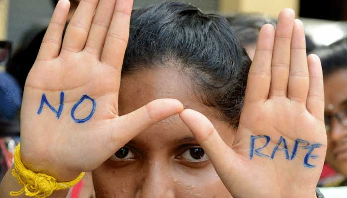A girl protesting against sexual violence in Pakistan shows her hands with No Rape written on the palms. — AFP