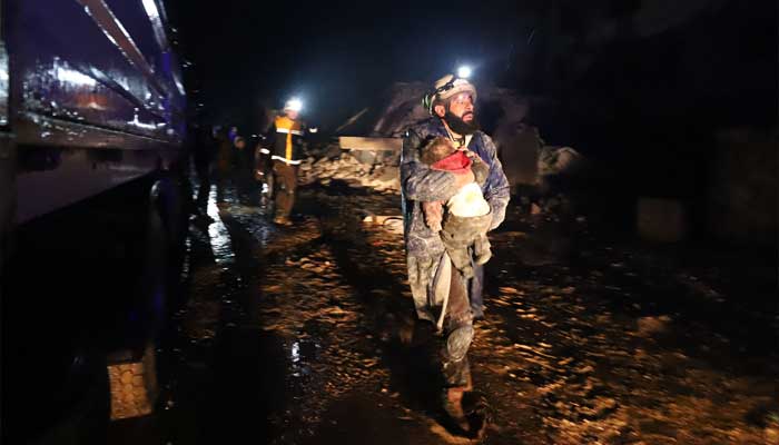 A member of the Syrian civil defence, known as the White Helmets, carries a child rescued from the rubble following an earthquake in the town of Zardana in the countryside of the northwestern Syrian Idlib province, early on February 6, 2023. — AFP