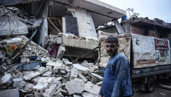 A resident stands in front of a collapsed building following an earthquake in the town of Jandaris, in the countryside of Syria's northwestern city of Afrin in the rebel-held part of Aleppo province, on February 6, 2023. — AFP