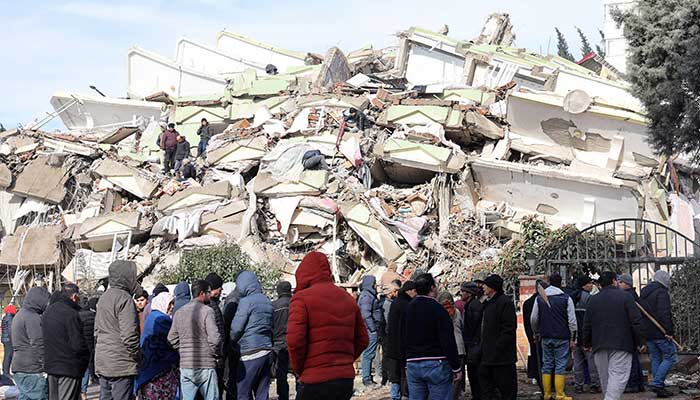 7 فروری 2023 کو ملک کے جنوب مشرق میں آنے والے 7.8 شدت کے زلزلے کے ایک دن بعد، جنوبی ترکی کے کہرامانماراس میں رضاکار تباہ شدہ عمارت کے ملبے پر کھڑے ہیں۔ - اے ایف پی