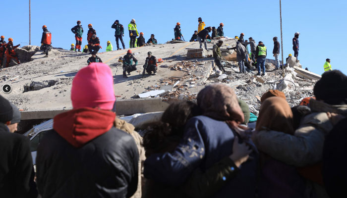 People watch as rescuers and civilians look for survivors under the rubble of collapsed buildings in Nurdagi, in the countryside of Gaziantep, on February 9, 2023, three days after a deadly earthquake that hit Turkey and Syria. — AFP
