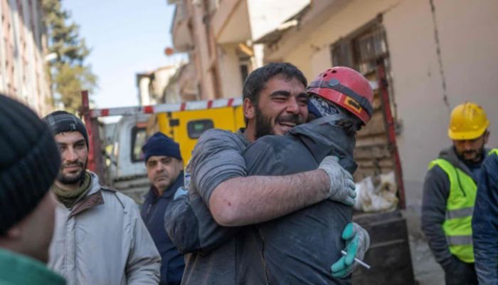 A miner (L), who rescued 16-year-old Melda after she was stuck for three days in rubble, reacts with a fellow rescue team member in Hatay, on February 9, 2023, three days after a 7,8-magnitude earthquake struck southeast Turkey.— AFP