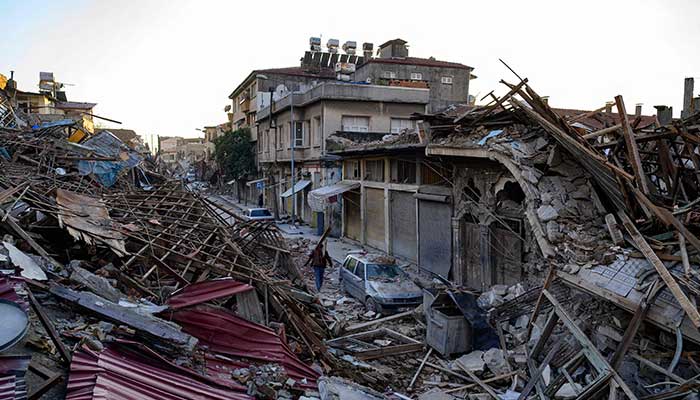 A man walks past the rubbles of destroyed building following two massive back-to-back earthquakes that affected both Turkey and Syria earlier in the week, in Antakiya, Hatay province, southern Turkey on February 10, 2023. — AFP