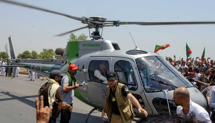 PTI chief Imran Khan arrives on a helicopter to lead a protest rally in Swabai on May 25, 2022. — AFP