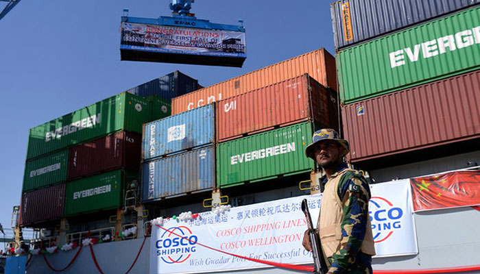 A security personnel stands guard beside a ship carrying containers on Gwadar port. AFP/File
