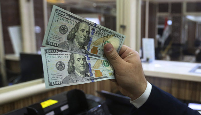 An employee counts banknotes at a currency exchange shop in Baghdad on February 14, 2023. — AFP