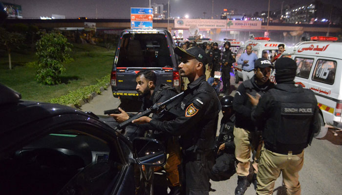 Polisler, 17 Şubat 2023'te Karaçi'deki bir polis yerleşkesine düzenlenen saldırı mahallinin yakınında pozisyon alıyor. — AFP