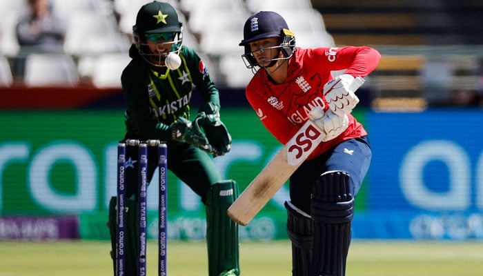 Englands Danni Wyatt (R) plays a shot while Pakistan´s wicketkeeper Muneeba Ali (L) looks on during the Group B T20 women´s World Cup cricket match between England and Pakistan at Newlands Stadium in Cape Town on February 21, 2023. — AFP