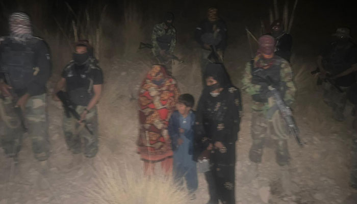 Naz and her children are seen walking with the Levies personnel after being rescued. — Geo News