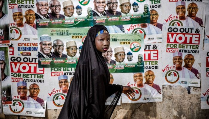 A girl walks in front of electoral posters in support of the opposition Peoples Democratic Party at Ribadu Square, Jimeta, Adamawa State, Nigeria where the PDP is set to hold a rally, on February 14, 2019.— AFP
