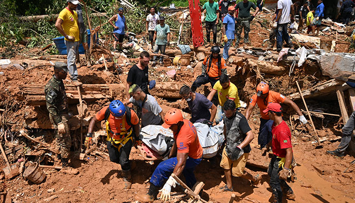 Rescue personnel transport the body of a victim after a flood in Barra do Sahy, Sao Sebastiao district, Sao Paulo state, Brazil on February 21, 2023. AFP