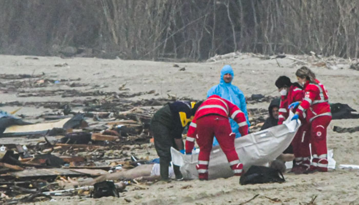 26 Şubat 2023'te İtalyan haber ajansı Ansa'dan alınan bu fotoğraf, kurtarıcıların İtalya'nın güney Calabria bölgesi açıklarında bir göçmen teknesinin batmasının ardından Crotone'nin güneyindeki Steccato di Cutro'daki bir gemi enkazında bir ceset torbasını idare ettiğini gösteriyor.  — AFP