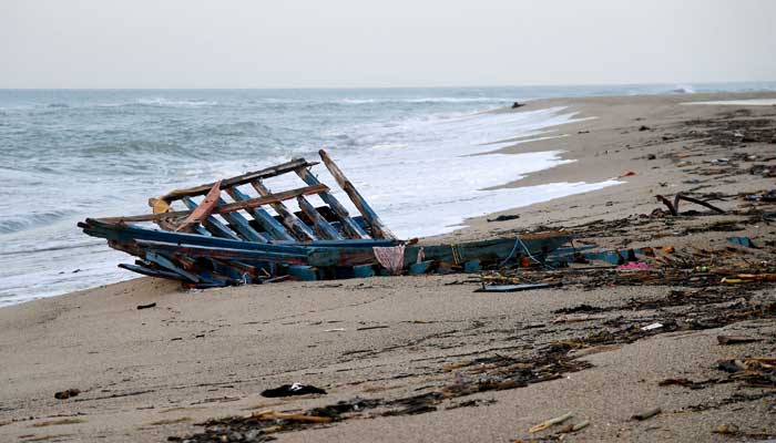 28 Şubat 2023'te çekilen bir fotoğraf, Crotone'nin güneyindeki Steccato di Cutro'da, İtalya'nın güney Calabria bölgesi açıklarında battıktan iki gün sonra sahile vuran bir göçmen teknesinin parçalarını gösteriyor.  — AFP