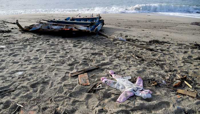 28 Şubat 2023'te çekilen bir fotoğraf, İtalya'nın güney Calabria bölgesinde, Crotone'nin güneyindeki Steccato di Cutro'da bir göçmen teknesinin batmasından iki gün sonra sahile vuran bir tulum ve odun parçalarını gösteriyor.  — AFP