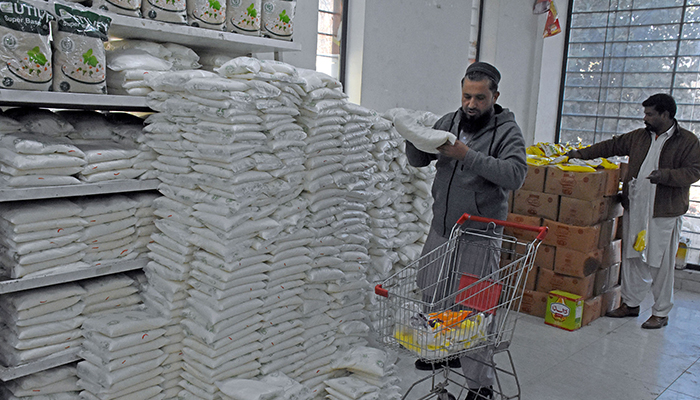 A man buys a sugar bag at a Utility Store in Islamabad on January 4, 2023. — Online