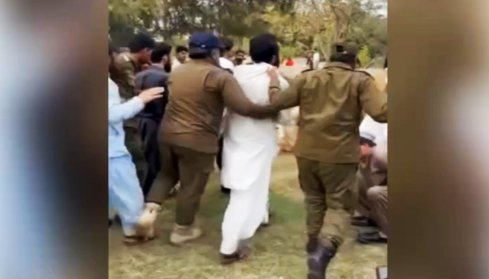 Police take a student into custody following the clash at the University of Punjab in Lahore on March 1, 2023, in this still taken from a video. — Geo News