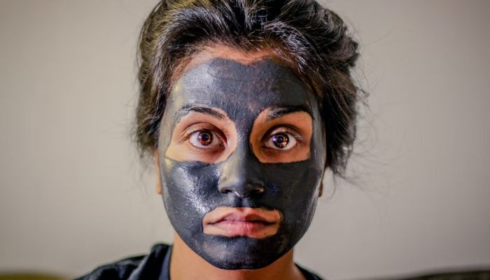 Image shows a woman wearing a clay mask.— Unsplash