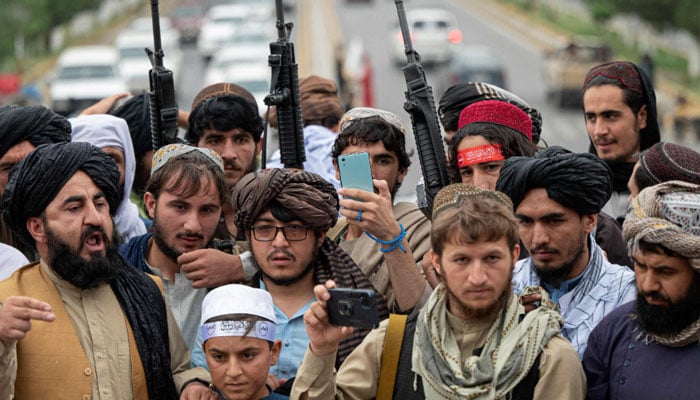 15 Ağustos 2022'de çekilen bu dosya fotoğrafında, Taliban savaşçıları iktidara dönüşlerinin birinci yıl dönümü münasebetiyle Kabil'deki Ahmed Şah Mesud Meydanı'nda zafer sloganları atarken ellerinde tüfekler var.  — AFP