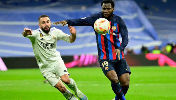 Real Madrid´s Spanish defender Dani Carvajal (L) fights for the ball with Barcelona´s Ivorian midfielder Franck Kessie during the Copa del Rey (King´s Cup) semi final first leg football match between Real Madrid CF and FC Barcelona at the Santiago Bernabeu stadium in Madrid on March 2, 2023. AFP
