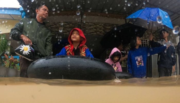 Malezya'nın Johor eyaletindeki Yong Peng'de sel baskınına uğrayan bir aile tahliyeye hazırlanıyor.— AFP